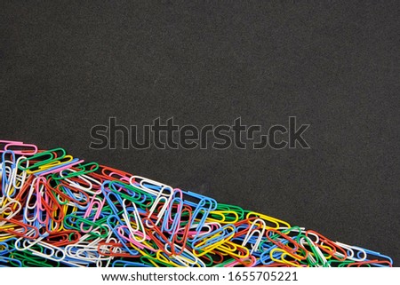color paper clips on black background                