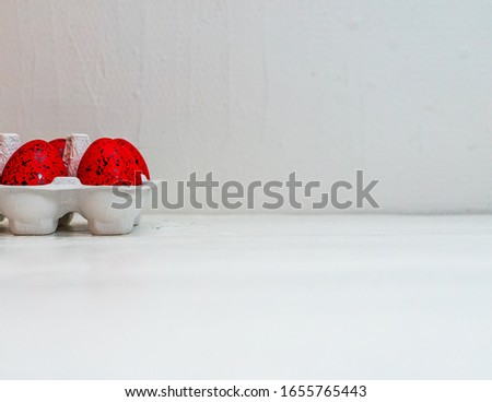 Easter set with red and  black ornated eggs in carton isolated on white background with copy space.