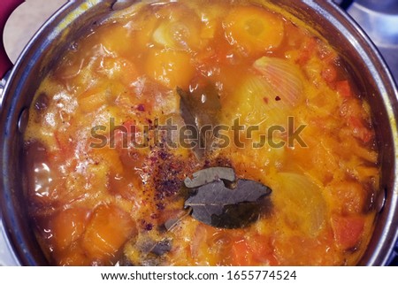 cooking pumpkin soup puree in a saucepan. pumpkin puree in a copper decorative saucepan top view isolated