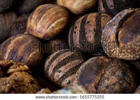 large assortment of freshly baked bread at local bakery, stacked loaves, artisan loaf of bread