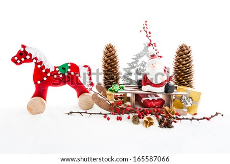 Close up of Santa sitting on wooden horse sledge holding gift and presents - white and red christmas background,  isolated decoration