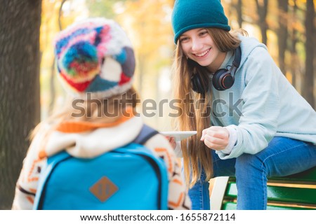 Older sister meets schoolgirl in autumn park