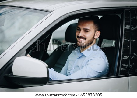 Handsome man driving a luxury car smiling Royalty-Free Stock Photo #1655873305