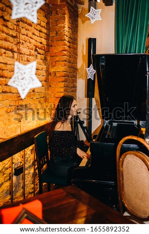 Incredible girl playing the piano in a cozy restaurant