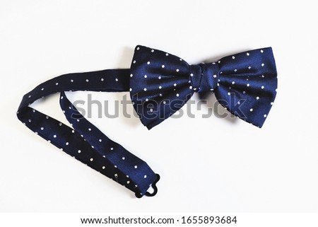A blue bow with white dots on a white background
