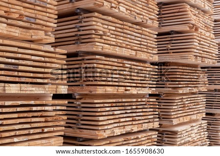 large stacks of wooden planks full frame background with selective focus and linear perspective