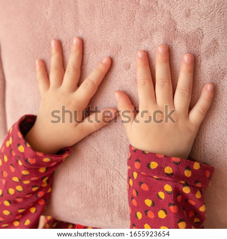 hands of a little girl on a soft pillow