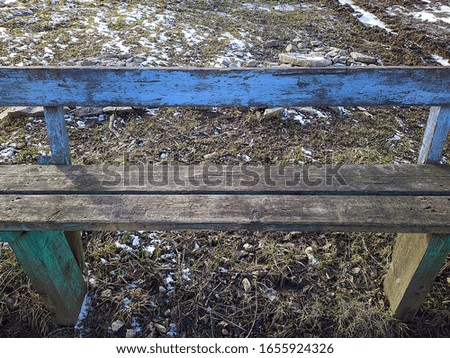 old wooden bench in the yard at the beginning of winter
