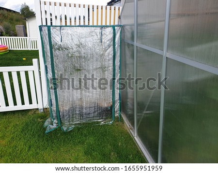 Close up view of two kind of greenhouses on backyard. Gardening concept.