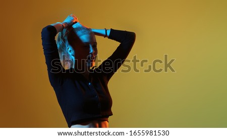 pretty teenage model in studio with blue and orange light. Model enjoying a photo shoot