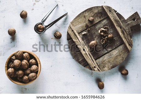 Walnuts in wooden bowl on table with Nutcracker.