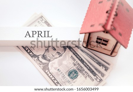 Inscription of the month of April as a reminder of the payment of a mortgage or the purchase of a house, apartment. Wooden house with property financial concept. 