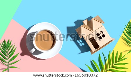 Cardboard house with a cup of coffee - flat lay
