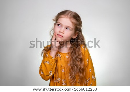 Sign fingers quieter shows a little girl with long blonde curly hair in an orange dress. Portrait - quiet. Quickly.