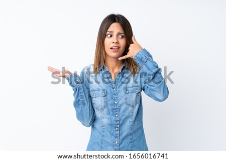 Young woman over isolated white background making phone gesture and doubting
