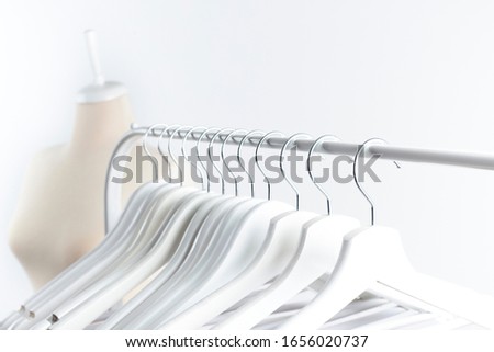 tailor mannequin and empty clothes hangers on white background
