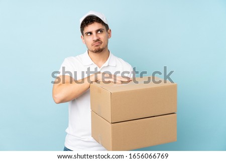 Delivery caucasian man isolated on blue background thinking an idea