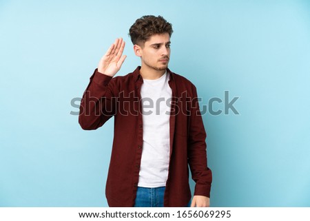 Young caucasian man isolated background making stop gesture and disappointed