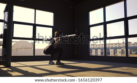 Woman with heavy barbell squat exercise in fitness gym healthy lifestyle muscle builder, Athletic sport woman training endurance strong focus legs workout.