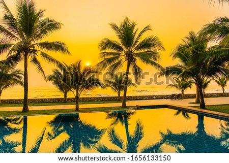 Beautiful nature with palm tree around outdoor swimming pool in hotel resort nearly sea ocean beach