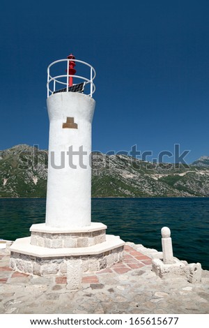 White lighthouse tower on the island of Lady of the Rocks. Bay of Kotor, Montenegro