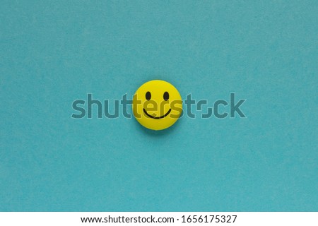 Yellow funny smiley face on blue background. Positive mood concept Royalty-Free Stock Photo #1656175327