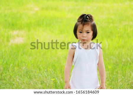 The little girl sitting on the grass
