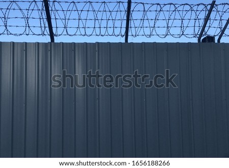 Gray barricade and accordion barbed wire.