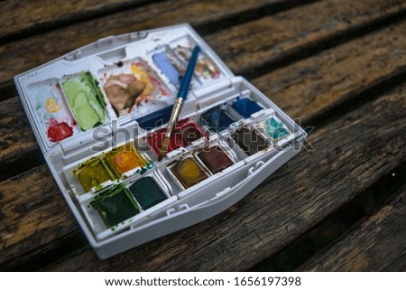 Watercolors paint box on a wooden board