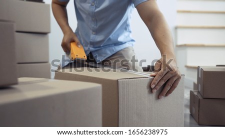 Delivery man packing parcel from shopping online delivery to customer, Safety package cardboard order at office or warehouse, sme owner entrepreneur concept.  Royalty-Free Stock Photo #1656238975