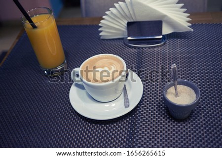 cup of coffee on the table orange juice and napkins