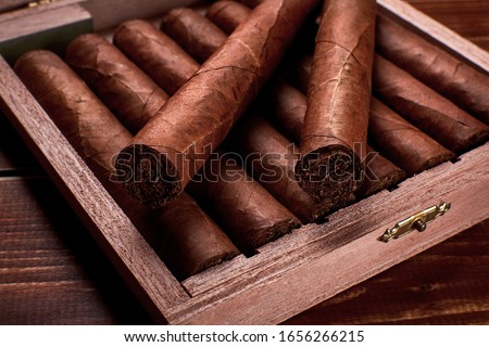 Closeup photo of a wooden box with cuban cigars and space for text Royalty-Free Stock Photo #1656266215