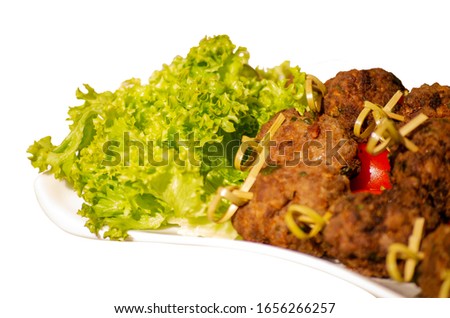 meatballs on a white plate and lettuce close up focus