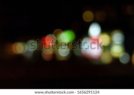Bokeh neon shining shop windows and street lamps. Blurred image of neon lights in the shop windows in the city at night. Bokeh elements. Creative background for montage and design.