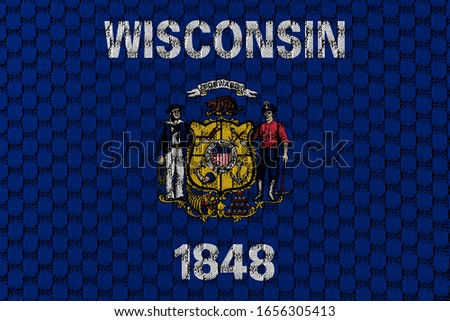 The national flag of the US state Wisconsin in against a gray textile material with sew thread on the day of independence in different colors of blue red and yellow. Clothing and industry.
