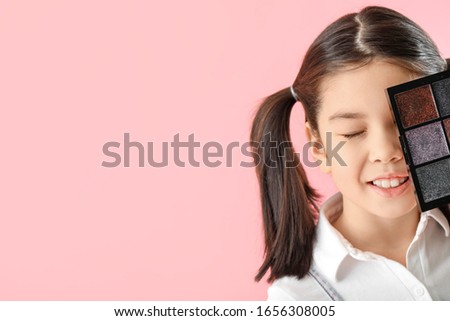 Cute little makeup artist on color background