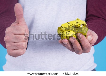 man making ok sign and with measuring tape.concept of diet and health