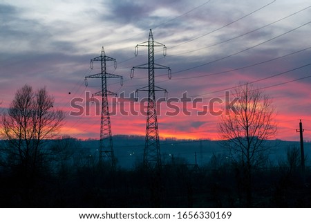 Power poles and a beautiful sunset. The sky is like fire. Rising energy prices - concept