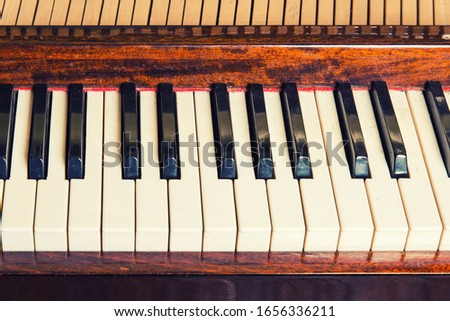 Piano keyboard background with selective focus. Warm color toned image Royalty-Free Stock Photo #1656336211