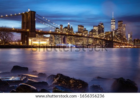 New York skyline during the blue hour with Brooklyn bridge and the One World Trade Center in the background.