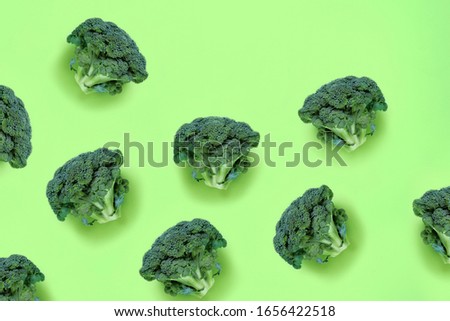 Broccoli on a green background. Seamless food pattern in a minimalistic style, photo collage. Concept of diet, healthy food. Top view, flat lay, copy space for text.