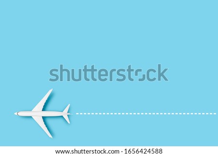 Airplane and line indicating the route on a blue background. Concept travel, airline tickets, flight, route pallet. Banner. Flat lay, top view