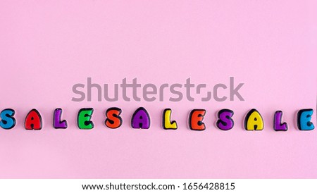 Inscription SaleSaleSale composed of colored letters on a pink background. Discount and advertisement. Seasonal sale in stores. The photo for a banner or poster on the site and on social networks
