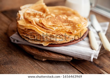 Thin pancakes on a plate. Homemade crepes, tasty food. Staple of yeast pancakes, traditional for pancake week (Shrove tide). Thin pancake with crispy crust.  Royalty-Free Stock Photo #1656463969
