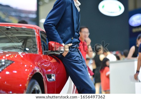 Royalty high quality free stock photo an unidentified man in a suit is leaning against his red car