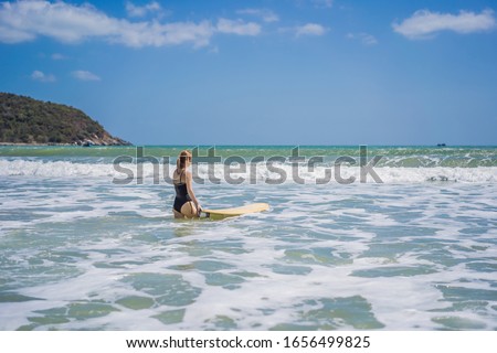Beautiful young woman ride wave. Sporty surfer woman surfing on the background of blue sky, clouds and transparent waves. Outdoor Active