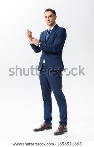full length view of successful young tattooed businessman in blue suit isolated on white