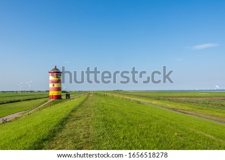 Pilsum Lighthouse on the Dike with  Clear Blue Sky, East Frisia, North Sea Coast, Germany Royalty-Free Stock Photo #1656518278