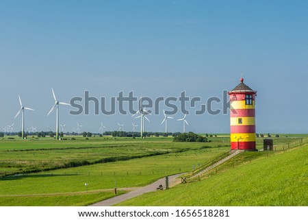 Pilsum Lighthouse with Wind Turbines, North Sea, East Frisia, Germany  Royalty-Free Stock Photo #1656518281