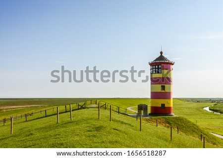 Pilsum Lighthouse on the Dike on the East Frisian North Sea Coast, Germany Royalty-Free Stock Photo #1656518287